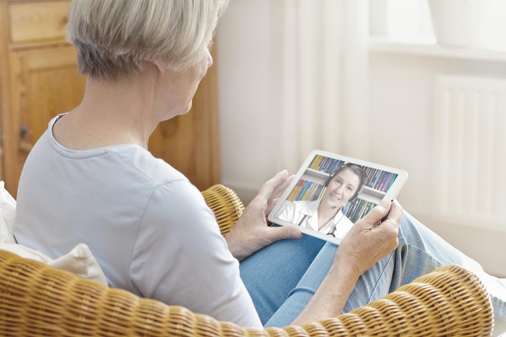 older woman talking with doctor on ipad